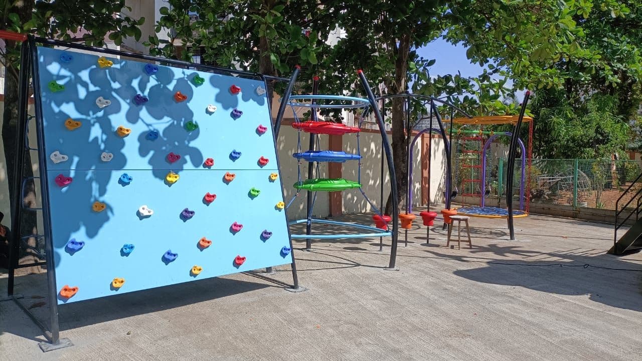 The school's colourful outdoor play area under shade trees